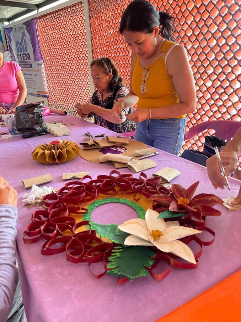 Mujeres participan en el Taller de Elaboración de Coronas Navideñas con material reciclado en el Instituto de la Mujer de Cuernavaca, promoviendo creatividad, reciclaje y autonomía económica.