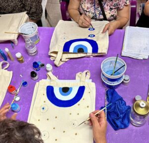Mujeres participando en Taller de pintura sobre bolsas de tela del IMC en Cuernavaca como parte del programa FAEM.