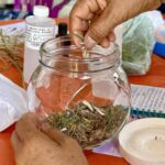 Mujeres participan en el taller de elaboración de oleato para ansiedad y descanso impartido por el IMC como parte de las actividades del programa FAEM.