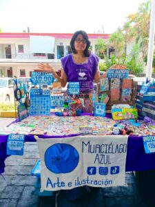 Emprendedoras participan en la Cooperativa Violeta organizada por el IMC en la explanada del Ayuntamiento de Cuernavaca, exhibiendo artesanías, alimentos y productos elaborados por ellas.