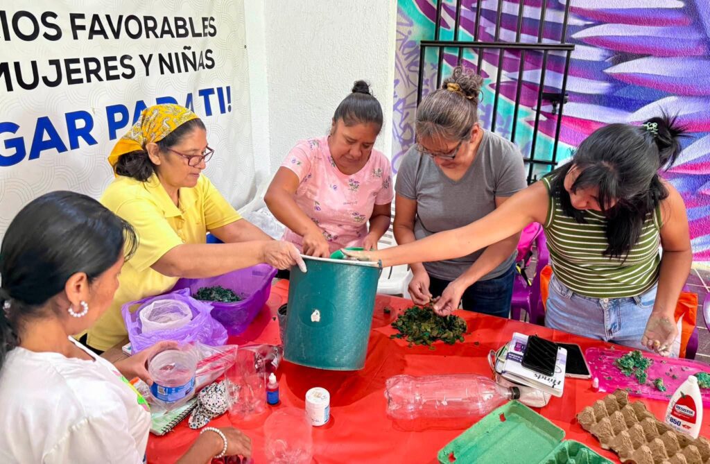 Usuarias del IMC participan en el taller de masa de papel, elaborando figuras decorativas con materiales reciclados como parte de una actividad de educación ambiental.