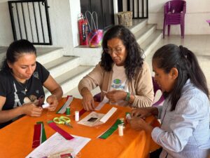 Participantes del FAEM elaboran moños patrios durante un taller en el Instituto de la Mujer de Cuernavaca (IMC)
