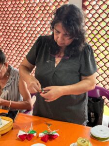 Participantes del FAEM elaboran moños patrios durante un taller en el Instituto de la Mujer de Cuernavaca (IMC)