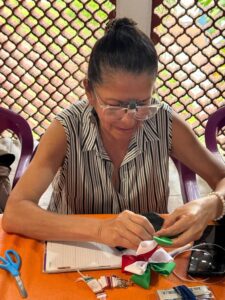 Participantes del FAEM elaboran moños patrios durante un taller en el Instituto de la Mujer de Cuernavaca (IMC)
