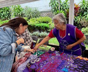 Integrantes de la Cooperativa Violeta del IMC exhiben sus productos en la Universidad La Salle, promoviendo el emprendimiento y la autonomía económica de las mujeres.