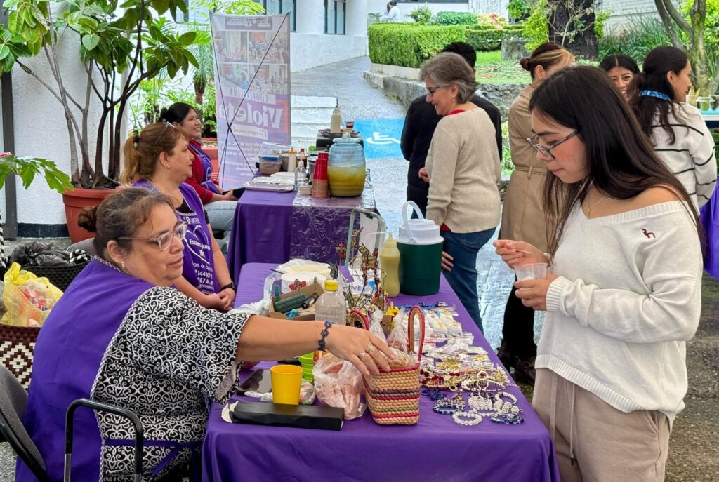 Integrantes de la Cooperativa Violeta del IMC exhiben sus productos en la Universidad La Salle, promoviendo el emprendimiento y la autonomía económica de las mujeres.
